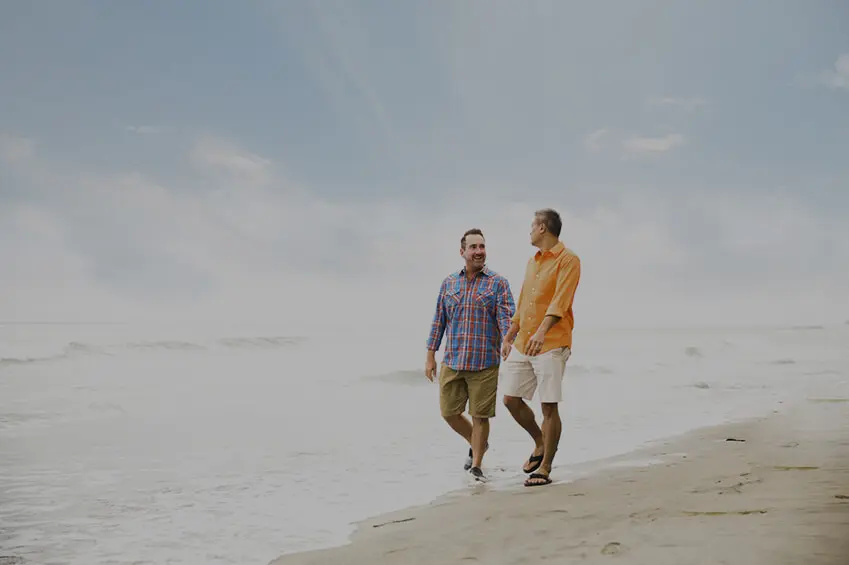Affectionate Interracial Gay Couple Walking on a Beach
